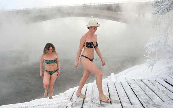 Dok se iznad površine diže tanak oblak pare, tela  članova kluba „Kriofil“ presecaju vodu koja izgleda gotovo nadrealno mirna u takvoj hladnoći. - Sputnik Srbija