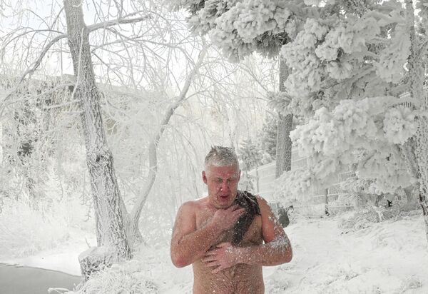 Muškarac iz kluba zimskog plivanja „Kriofil“ „maže“ se snegom posle kupanja u Jeniseju pri temperaturi vazduha od oko minus 30 stepeni Celzijusa u Krasnojarsku. - Sputnik Srbija