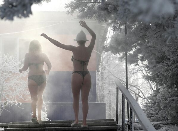 Devojke iz kluba zimskog plivanja „Kriofil“ hodaju kroz magloviti vazduh posle kupanja u Jeniseju pri temperaturi od oko minus 30 stepeni Celzijusa u Krasnojarsku. - Sputnik Srbija