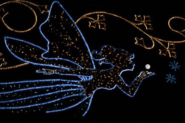 Pun mesec iza svetiljke u obliku vile koja izgleda kao da duva ka Supermesecu na nebu u Londonu. - Sputnik Srbija