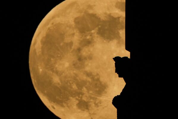 Supermesec se uzdiže iza statue na vrhu kule Spomenika slobode u Nacionalnom muzeju svetskog rata u Kanzas Sitiju. - Sputnik Srbija