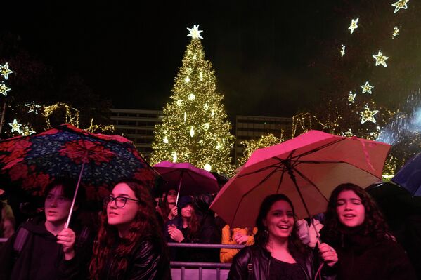 Људи на концерту током кише док је Атина осветљавала своју божићну јелку на тргу Синтагма. Људи на концерту током кише док је Атина осветљавала своју божићну јелку на тргу Синтагма. - Sputnik Србија