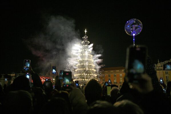 Гомила се окупља да гледа паљење култне божићне јелке високе 30 метара и ватромет на тргу Праса до Комерсио 22. новембра 2025. у Лисабону, Португалија. Ове године светла покривају укупно 182 километра и распоређена су на 46 локација, укључујући тргове, улице и авеније. Гомила се окупља да гледа паљење култне божићне јелке високе 30 метара и ватромет на тргу Праса до Комерсио 22. новембра 2025. у Лисабону, Португалија. Ове године светла покривају укупно 182 километра и распоређена су на 46 локација, укључујући тргове, улице и авеније. - Sputnik Србија