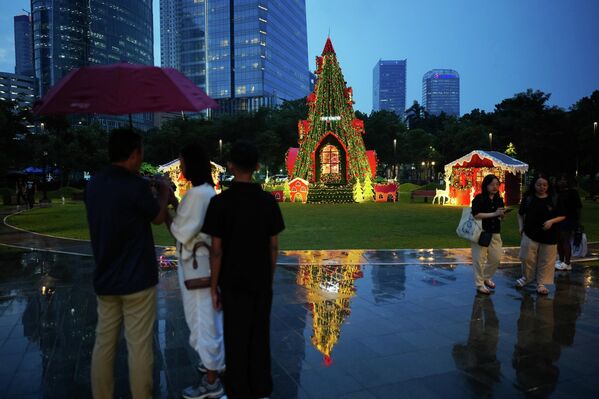Људи пролазе испред божићне јелке постављене у парку у Џакарти, Индонезија. Људи пролазе испред божићне јелке постављене у парку у Џакарти, Индонезија. - Sputnik Србија