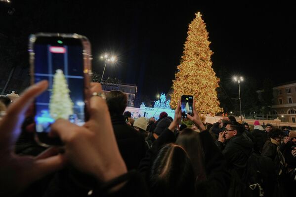 Људи фотографишу џиновску божићну јелку у Риму. Људи фотографишу џиновску божићну јелку у Риму. - Sputnik Србија