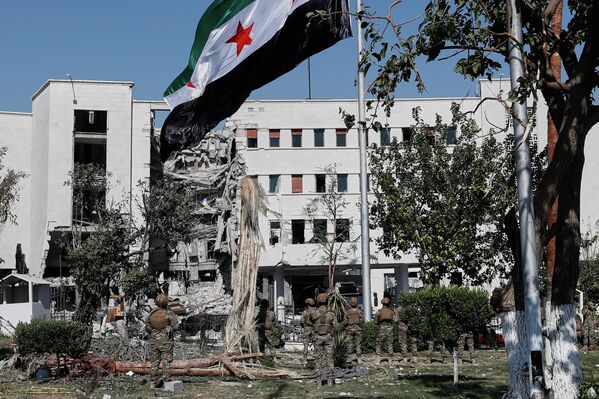 Сиријски војници подижу националну заставу испред зграде Министарства одбране у Дамаску која је тешко оштећена у израелским ваздушним нападима. - Sputnik Србија