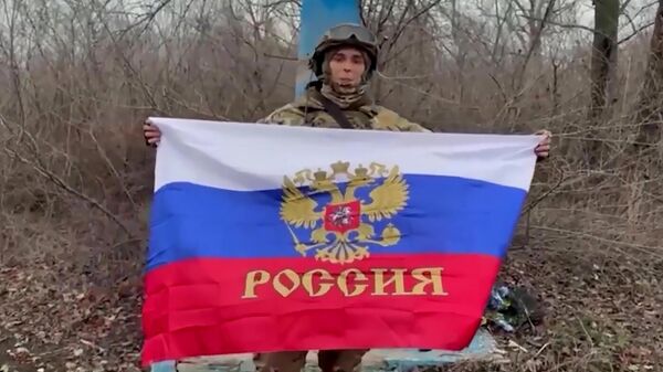 Руски војник са развијеном заставом Русије у ослобођеном Северску - Sputnik Србија