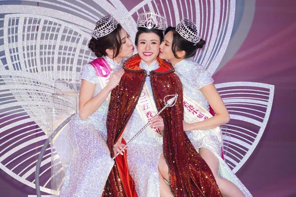 Прва пратиља Анђела Стентон, Мис Хонг Конга 2025. и Стејси Чен, друга пратиља Џејн Јуан позирају на избору за Мис Хонг Конга. - Sputnik Србија