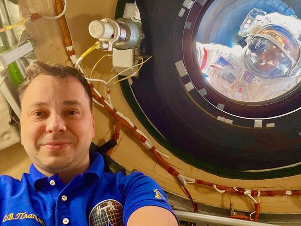 Космонаут Олег Платонов прави селфи на Међународној свемирској станици, док његове колеге Алексеј Зубрицки и Сергеј Рижиков раде напољу. - Sputnik Србија