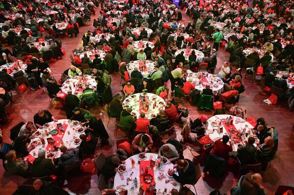 Берлин: Гости једу током 31. божићне забаве Франка Зандера за бескућнике и угрожене у хотелу Естрел. - Sputnik Србија