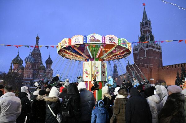 Туристи се возе на рингишпилу на тргу у Москви. - Sputnik Србија