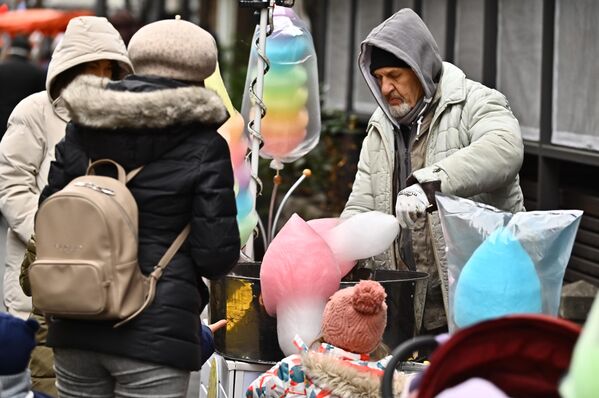 Док продавац намотава шећерну вуну, малишани посматрају и нестрпљиво чекају - Sputnik Србија