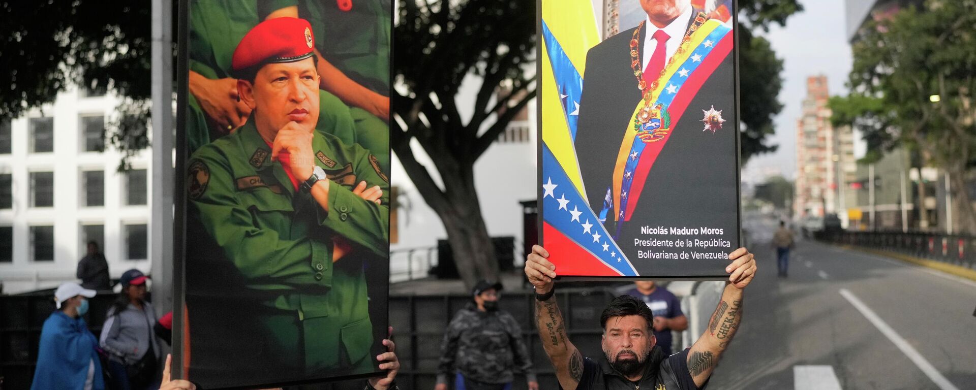 Government supporters display posters of Venezuelan President Nicolás Maduro, right, and former President Hugo Chávez in downtown Caracas, Venezuela, Saturday, Jan. 3, 2026. - Sputnik Srbija, 1920, 04.01.2026