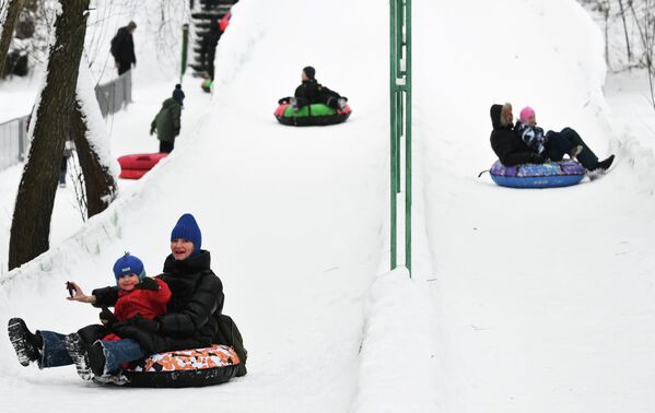 Становници се возе на гуменој гуми у парку 50. годишњице Октобра у Москви. - Sputnik Србија