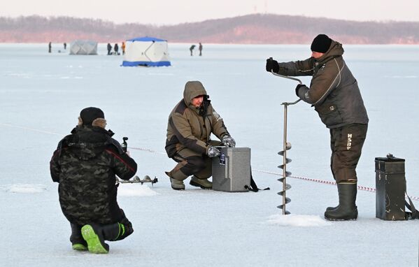 Učesnici zimskog festivala ribolova za Kup gradonačelnika „Kul Smelt“ pecaju kašikom na ledu u Bražnikovom zalivu u Vladivostoku. - Sputnik Srbija