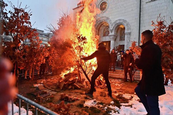 Испред Храма Светог Саве у Београду на Бадње вече традиционално је запаљен бадњак у присуству великог броја верника. - Sputnik Србија