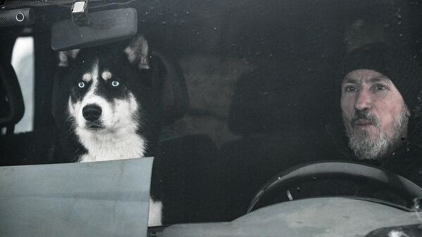 Учесник Првенства Новосибирске области и Јуниорског првенства у спортовима са псима на снежним санкама, „Божићна трка - 2026“, у аутомобилу са својим псом у спортском парку Ноздриха у научном граду Колцово. - Sputnik Србија