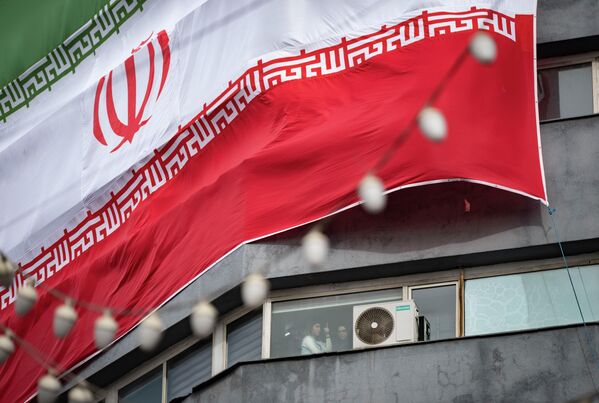 Две младе Иранке испод џиновске државне заставе током сахране погинулих у недавним немирима у Ирану, које иранска влада описује као браниоце безбедности. - Sputnik Србија