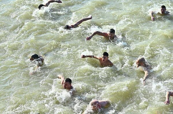 Тридесети три учесника су у духу заједништва заједно изнело крст из воде. - Sputnik Србија