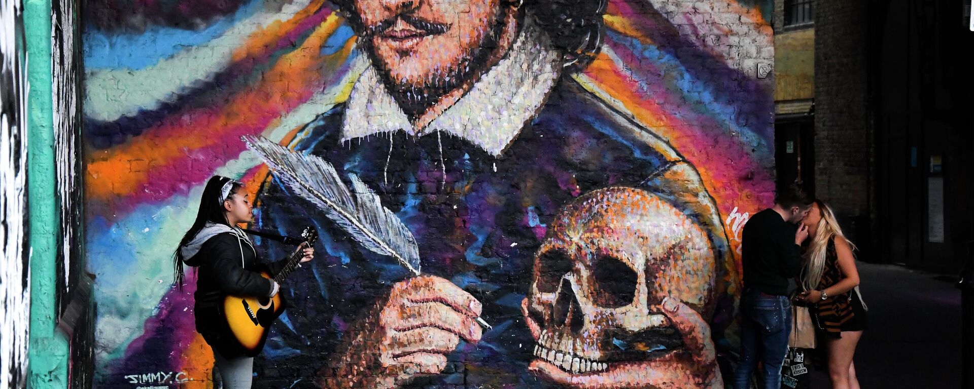Девојка свира гитару iспод мурала са Вилијама Шекспира на јужној обали реке Темзе - Sputnik Србија, 1920, 31.01.2026