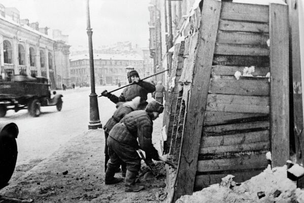 Велики отаџбински рат 1941–1945. Дана 27. јануара 1944. године завршена је херојска одбрана града на Неви, која је трајала 872 дана. После укидања блокаде Лењинграда, становници града уклањају заштитне конструкције са кућа у Садовој улици. Са леве стране види се зграда Гостињског двора. - Sputnik Србија