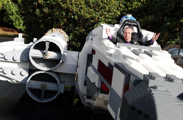 Глумац из филмског серијала „Ратови звезда“, Ворвик Дејвис, позира у највећем Лего моделу ловца Икс Винг на свету. - Sputnik Србија