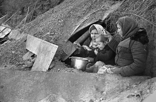 Пролеће 1943.године: Бескућници становници града на улазу у земуницу преуређену у станове. Пролеће 1943.године: Бескућници становници града на улазу у земуницу преуређену у станове. - Sputnik Србија