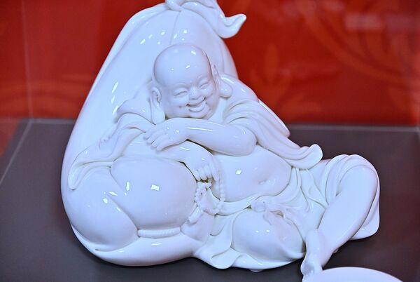 Бела порцеланска статуа Буде који се смеје, позната и као Будаи или Хотеи, израђена од порцелана из Дехуа. Ова фигура је симбол изобиља, среће и задовољства.  - Sputnik Србија