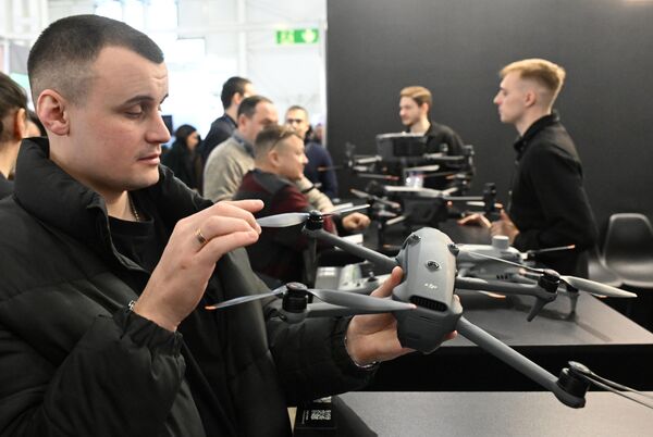 Посетилац држи квадрикоптер „Ди-Џеј-Ај“ (DJI) на изложби. - Sputnik Србија