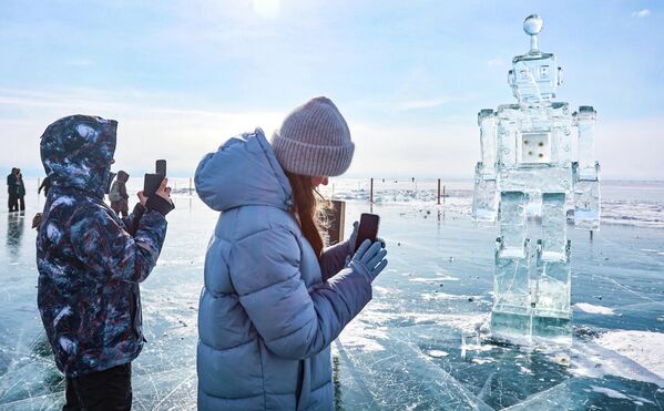Учесници 12. зимског фестивала ледене уметности „Живи на Бајкалу“ 2026. поред скулптуре робота у селу Листвјанка. Учесници 12. зимског фестивала ледене уметности „Живи на Бајкалу“ 2026. поред скулптуре робота у селу Листвјанка. - Sputnik Србија