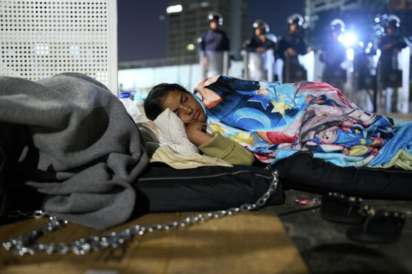 Жена спава испред притворског центра Зоне 7 Боливарске националне полиције док чека пуштање свог супруга, у Каракасу, Венецуела. - Sputnik Србија