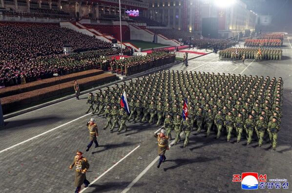 Војници на паради марширају у строју са заставама Русије и Северне Кореје. - Sputnik Србија