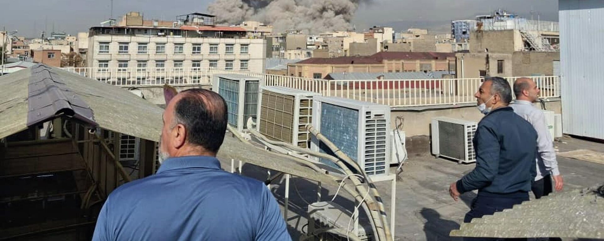 Люди наблюдают за поднимающимся над горизонтом дымом после взрыва в Тегеране, Иран - Sputnik Србија, 1920, 03.03.2026