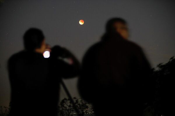 Ljudi fotografišu Mesec tokom potpunog pomračenja Meseca u Pančimalku, El Salvador. - Sputnik Srbija