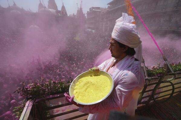 Свештеник прска обојени прах на вернике. - Sputnik Србија