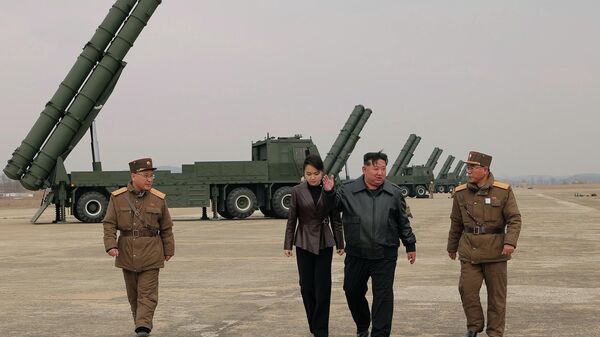 Фотографије агенције КЦНА приказују Кима и његову ћерку, Ким Џу Ае, стару око 13 година, како ходају поред огромних маслинастозелених лансирних камиона и гледају оружје које се лансира из њих. - Sputnik Србија