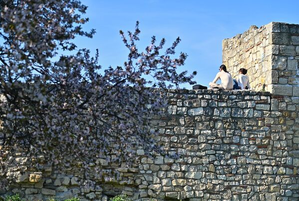 Младић и девојка уживају у пролећним зрацима сунца - Sputnik Србија