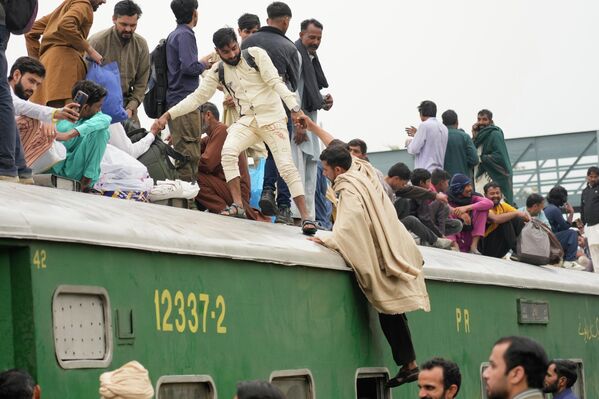 Људи се укрцавају у препун путнички воз како би стигли до својих кућа уочи празника. - Sputnik Србија