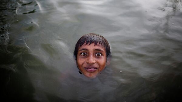 Rebenok plavaet v reke Buriganga vozle zavoda po pererabotke alюminiя na okraine Dakki, Bangladeš - Sputnik Srbija