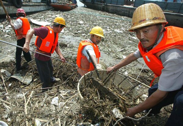 Радници сакупљају плутајући отпад из воде поред бродских преводница бране Три клисуре на реци Јангцекјанг, близу Јичанга, у централној кинеској провинцији Хубеј. - Sputnik Србија