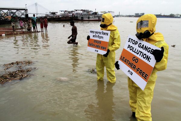 Активисти организације за заштиту животиња ПЕТА у оделима за биолошку опасност стоје у реци Ганг држећи плакате у знак протеста против загађења реке од стране кожарске индустрије у Калкути, у Индији. Смртоносне отпадне воде из фабрика коже дуж Ганга учиниле су је једном од најзагађенијих река на свету и одговорне су за загађење водних ресурса широм Индије и света. - Sputnik Србија