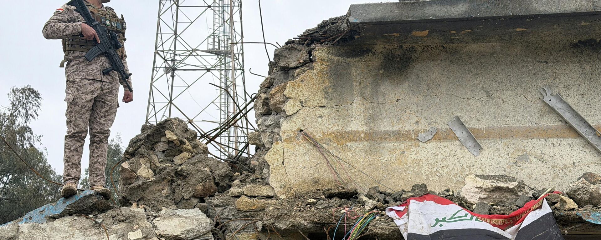 Ирачки војник на стражи на оштећеној згради у бази ирачке војске у Хабанији након што је погођена ваздушним нападом у среду, у провинцији Анбар - Sputnik Србија, 1920, 26.03.2026