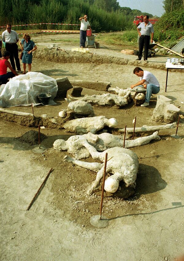 Археолог чисти гипсана тела жене и њеног сапутника, откривена заједно са још неколико ископаних скелета у Помпеји, 6. септембра 1991. године. Позиција тела указује да је мушкарац покушавао да заштити трудну жену док је древни град био закопан под пепелом и камењем током разорне ерупције Везува 79. године. - Sputnik Србија