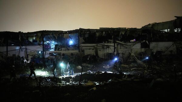 Израелске снаге безбедности и спасилачки тимови прегледају локацију погођену иранском ракетом у Петах Тикви - Sputnik Србија