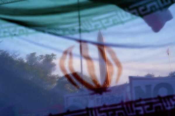 Вашингтонски споменик види се кроз иранску заставу током протеста против војне акције у Ирану. - Sputnik Србија