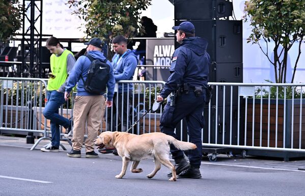 Припадник Министарства унутрашњих послова са службеним псом проверава трасу којом ће проћи тркачи - Sputnik Србија