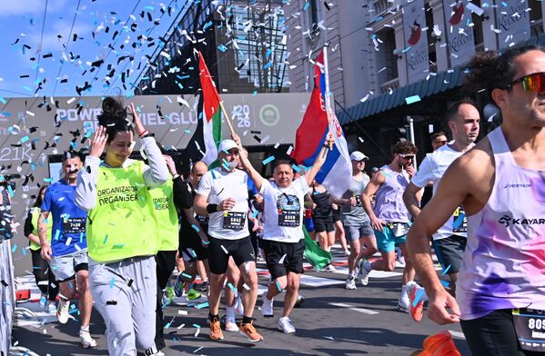 Један од учесника полумаратона, са старта је кренуо, носећи у рукама заставе Палестине и Србије - Sputnik Србија