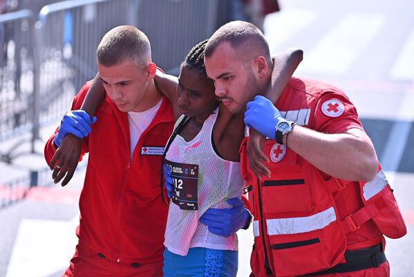 Због екстремног напора и брзог темпа који је наметнула, Кенијки је одмах по завршетку трке позлило, па су јој медицинске екипе притрчале у помоћ - Sputnik Србија