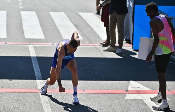 Победник маратона посматра славље другопласираног након проласка кроз циљ - Sputnik Србија