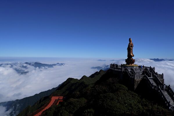 Статуа будистичке богиње Гуанин висока 12 метара на планини Фансипан надвија се над морем облака у Лао Каију, Вијетнам. - Sputnik Србија